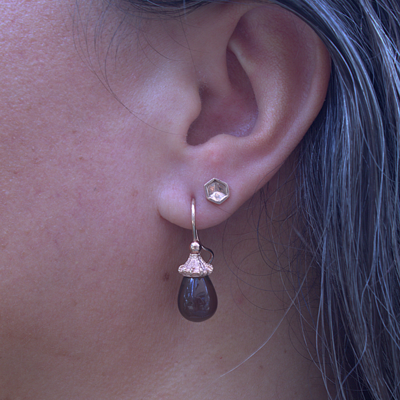 Gouden forest roos oorhaken met een natuurlijke kap waar de edelsteen in bevestigd is. De edelsteen heeft een prachtige ronde bolle druppelvorm. Duurzaam design en handgemaakt door Goudsmederij Goedbloed foto op model