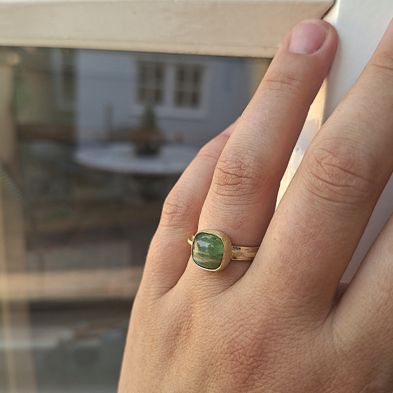 Een smeedring met een unieke antiek kussenvormige groene watermeloen Toermaline als kroonsteen gezet in een ijsgematteerde dichte zetting. handgemaakt door Goudsmederij Goedbloed foto op model