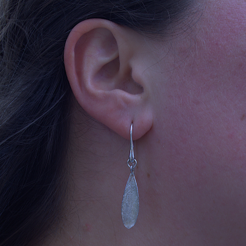 Zilveren olijf blad oorhaken met prachtige natuurlijke textuur van het blad. organisch en minimalistisch design duurzaam en handgemaakt door Goudsmederij Goedbloed foto op model