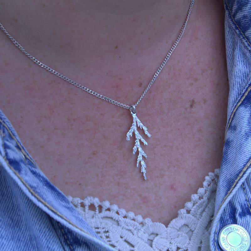 Zilveren kerst tak ceder hanger. organisch en romantisch ontwerp handgemaakt door Goudsmederij Goedbloed foto op model