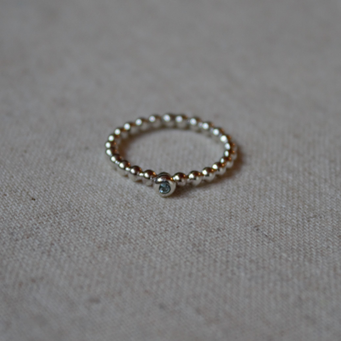 Zilveren balletjes aanschuifring met fijne witte Saffier in een donutzetting handgemaakt door Goudsmederij Goedbloed