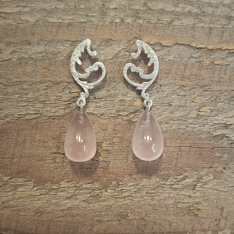 Zilver 925 asymmetrische oorstekers met art nouveau krulwerk en met een unieke druppelvormige rozenkwarts. Handgemaakt ontwerp door Goudsmederij Goedbloed