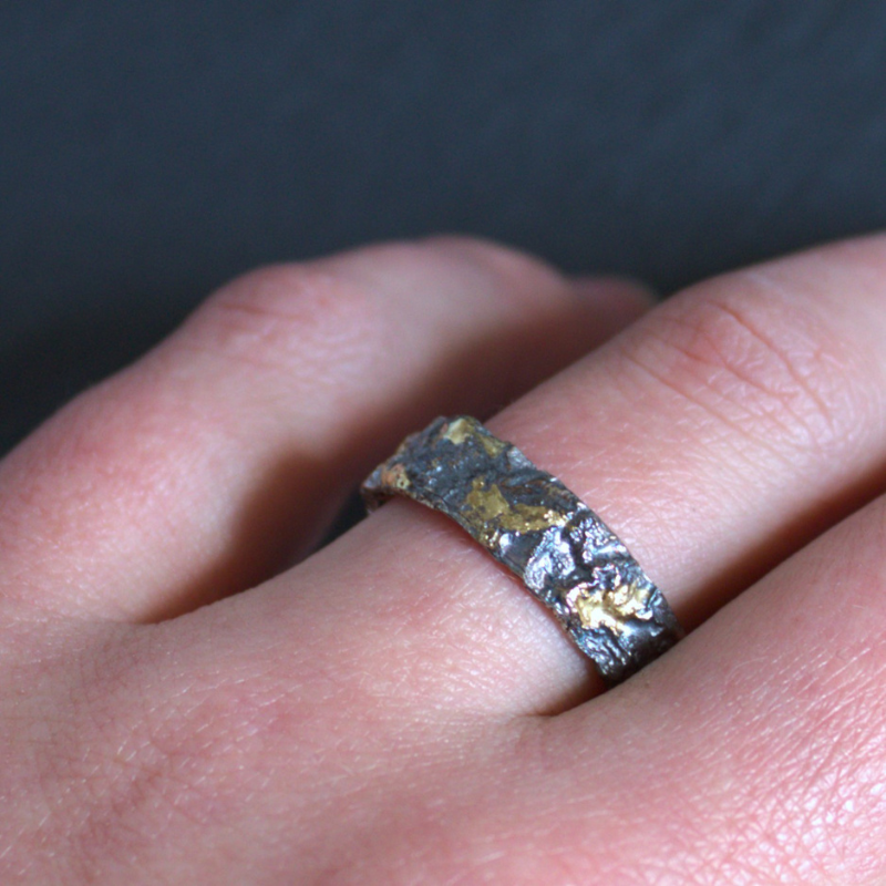 Robuuste zwart geoxideerde zilveren relatieringen met 14 karaat gouden elementen ontworpen en gesmeed door Goudsmederij Goedbloed