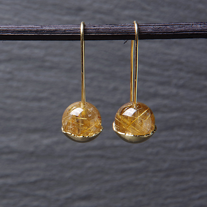 Lange gouden oorhaken met rutielkwarts in een kommetje. Handgemaakt door Goudsmederij Goedbloed