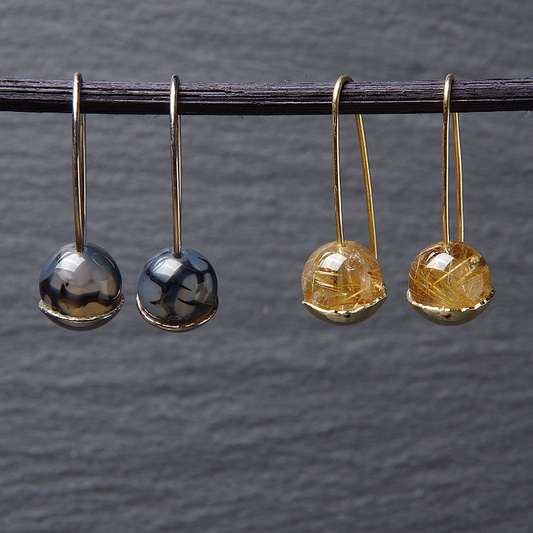 Lange gouden oorhaken met diverse rondgeslepen edelsteen in een kommetje. Handgemaakt design door Goudsmederij Goedbloed