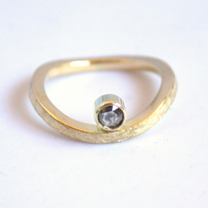 Eigentijds design 14 karaat gouden ring met een golvende ijs gematteerde band en een roosgeslepen zout en peper diamant gezet in een strakke gesloten kast  handgemaakt door Goudsmederij Goedbloed