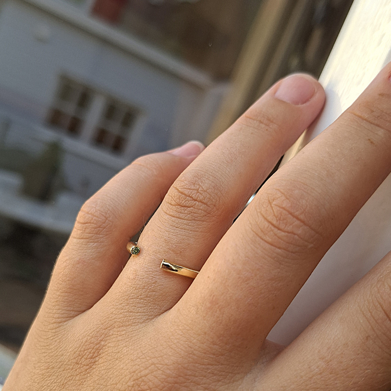 Open minimalistische ring met een ronde ringband waarin 2 briljant geslepen diamanten zijn gezet. Handgemaakt design door Goudsmederij Goedbloed foto op model