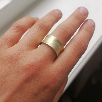 Trouwringen in een gesmede zandlopervorm met als afwerking een ijsmattering handgemaakt en ontwerp door Goudsmederij Goedbloed