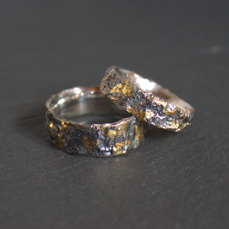 Robuuste zwart geoxideerde zilveren relatieringen met 14 karaat gouden elementen ontworpen en gesmeed door Goudsmederij Goedbloed