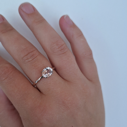 Natuurlijk witgouden solitaire ring met ovale facet geslepen roze Morganiet in een klassieke chatonzetting. Handgemaakt en duurzaam door Goudsmederij Goedbloed foto op model