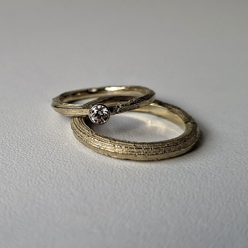 Organische minimalistische luxe Forest trouwringen met de lange textuur van Angelica, de dames ring heeft een bruine diamant solitaire rondomzetting. Handgemaakt bewust  design door Goudsmederij Goedbloed