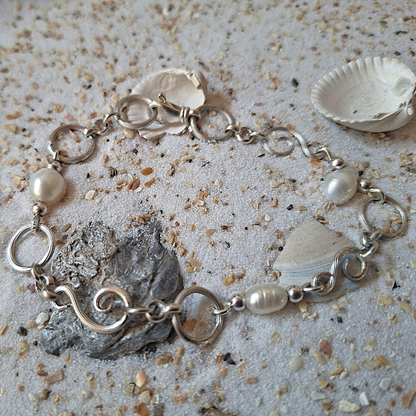 Zilveren zee geinspireerde armband met gekrulde schakels en witte zoetwaterparels. Natuurlijk ontwerp handgemaakt door Goudsmederij Goedbloed
