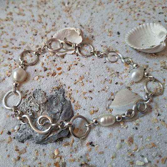 Zilveren zee geinspireerde armband met gekrulde schakels en witte zoetwaterparels. Natuurlijk ontwerp handgemaakt door Goudsmederij Goedbloed