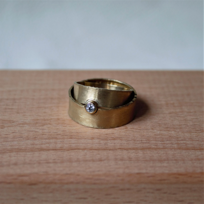 Geelgouden trouwringen met satijn gematteerde vlakke band met briljant geslepen diamant uit de Classic collectie handgemaakt door Goudsmederij Goedbloed