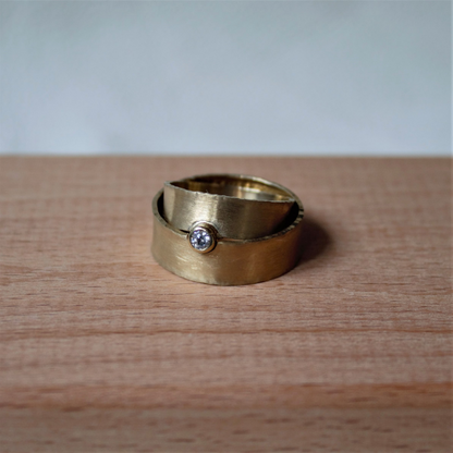 Geelgouden trouwringen met satijn gematteerde vlakke band met briljant geslepen diamant uit de Classic collectie handgemaakt door Goudsmederij Goedbloed