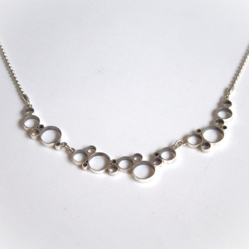 Zilveren collier met speelse cirkels als versierende elementen handgemaakt door Goudsmederij Goedbloed